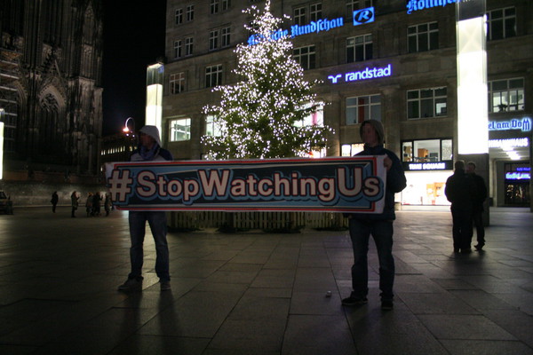 [Foto: Stop-Watching-Us-Banner vor Weihnachtsbaum]