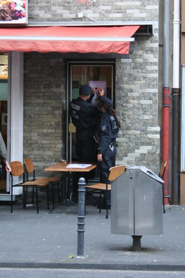 [Foto: Polizeiliche Plakatier-Einheit bringt Plakat an]