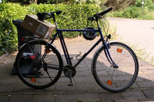 [Photo: Fahrrad vor Garage. Paket auf Gepcktrger]