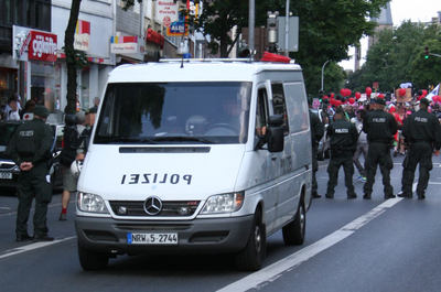 [Foto: Kamera-Wagen vor Versammlung]