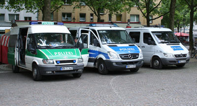 [Foto: Polizei-Autos und Polizisten]