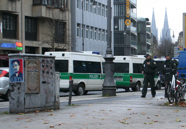 [Foto: Asyl-fr-Snowden-Plakat mit Polizei und Klner Dom im Hintergrund]