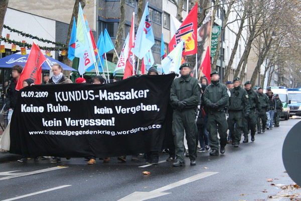 [Foto: Demo-Zug mit engmaschiger Polizei-Begleitung]