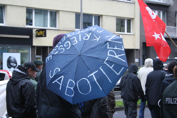 [Foto: Regenschirm mit Aufschrift Kriegprofiteure sabotieren]