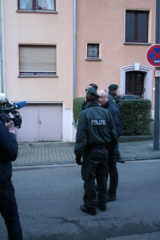 [Foto: Polizist und Gerichtsvollzieher beraten weiteres Vorgehen]