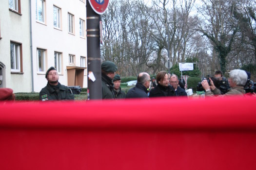 [Foto: Blick von Versammlung auf Polizei und Gerichtsvollzieher]