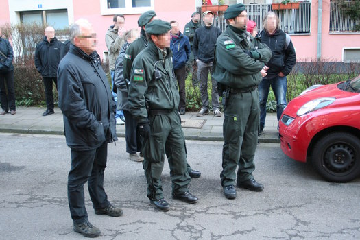 [Foto: Gerichtsvollzieher und Polizei lauschen Trommelkonzert]