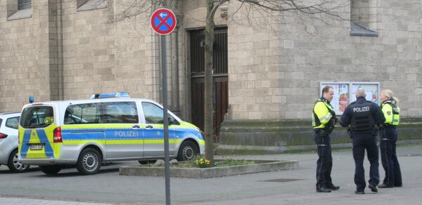 [Foto: Polizei-Bus und Polizistin und Polizisten]