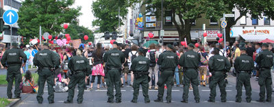 [Foto: Polizisten vor Versammlung]