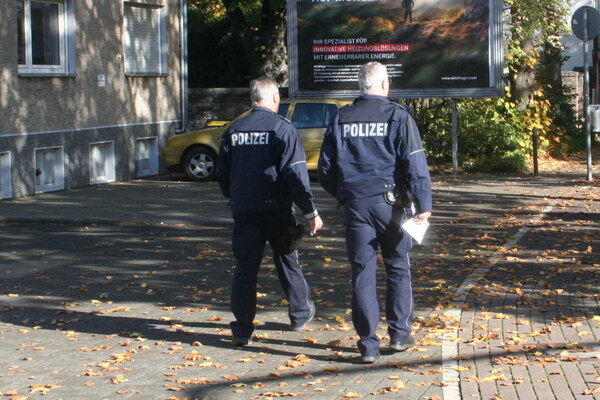[Foto: Zwei Polizisten verlassen die Versammlung]