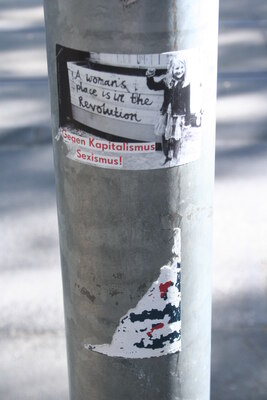 [Foto: 'A woman's place is in the revolution' und weitere Aufkleber]