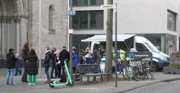 [Foto: Polizisten und Journalisten vor Polizei-Bus]